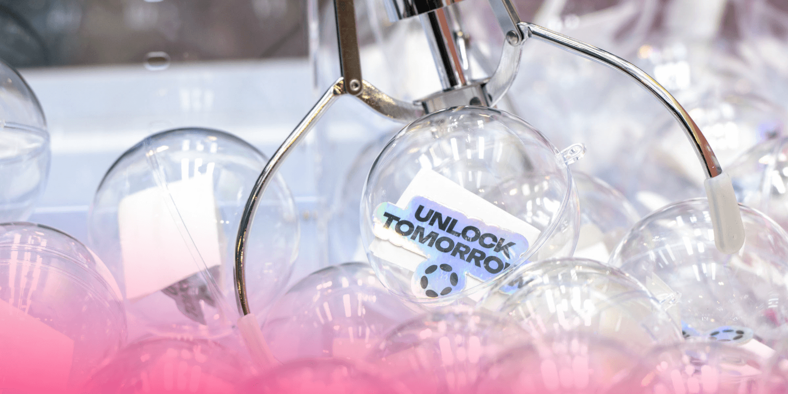 Close-up of the Polkadot claw machine at Consensus 2025, capturing a capsule with a holographic 'Unlock Tomorrow' sticker inside a clear plastic orb.