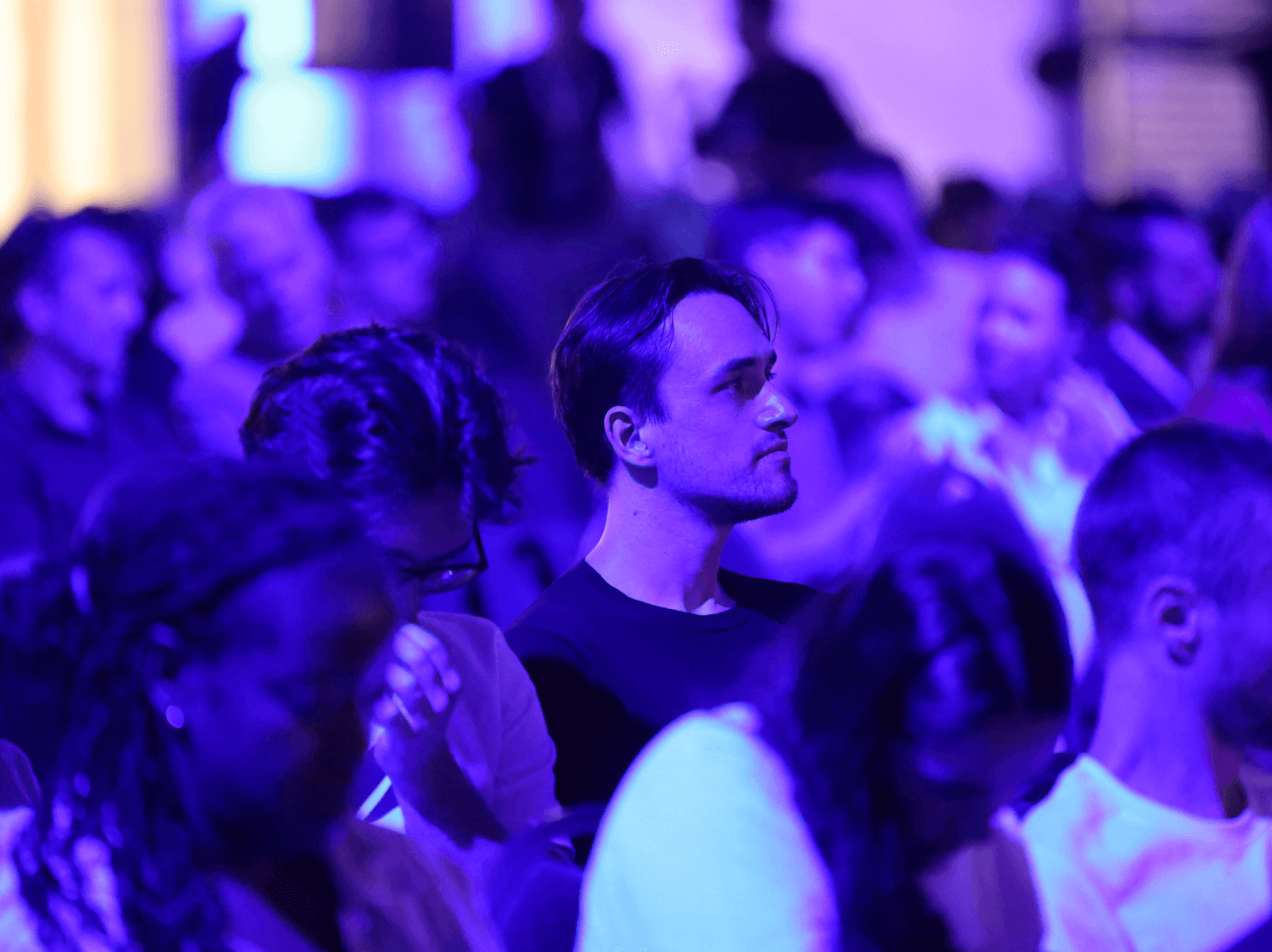 Audience member at a Polkadot event under pink and purple lighting