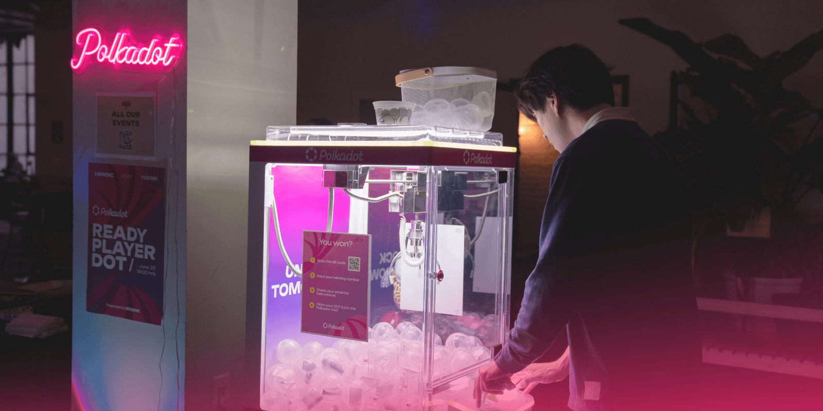 Attendee plays with a bright pink Polkadot claw machine