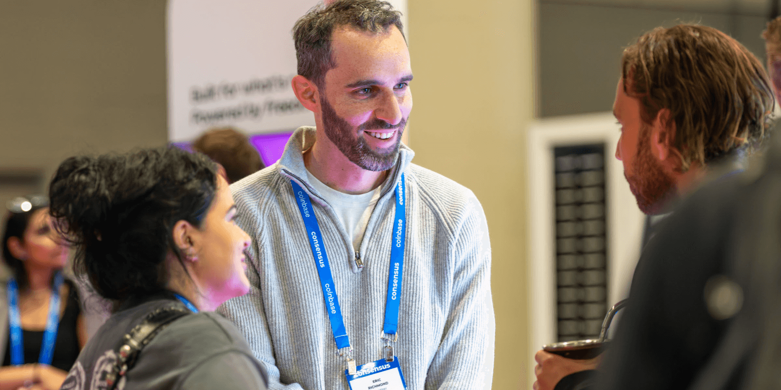 Attendees at Consensus 2025 chat near the Polkadot booth, networking and exchanging ideas during the conference’s busy exhibition floor.